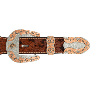 A custom western three piece belt buckle set featuring a cowboy figure and copper accents 